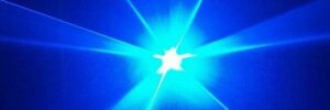 Bright blue laser light with radiant beams extending outward in multiple directions against a dark background.