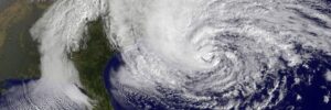 Satellite image shows a large hurricane with swirling clouds nearing the coast, threatening pond repair restoration efforts.