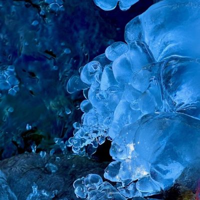 Close-up of irregularly shaped ice formations with a deep blue background.